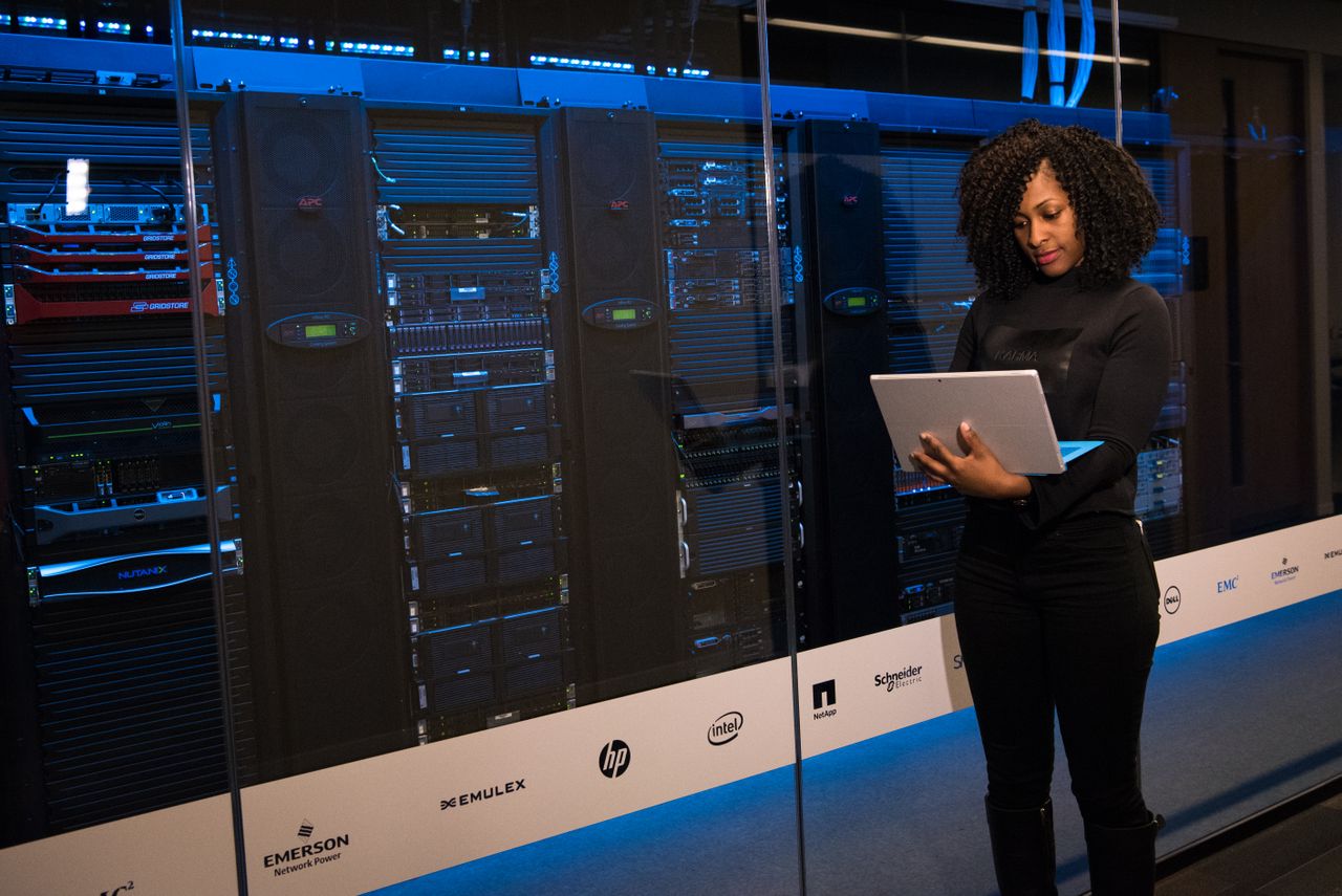 Engineer with a laptop monitoring server racks, the kind of managed hosting Liquid Web provides