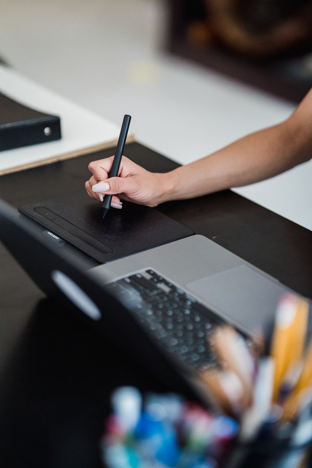 Graphic designer using a drawing tablet and laptop, the kind of skill sold on freelance money making sites