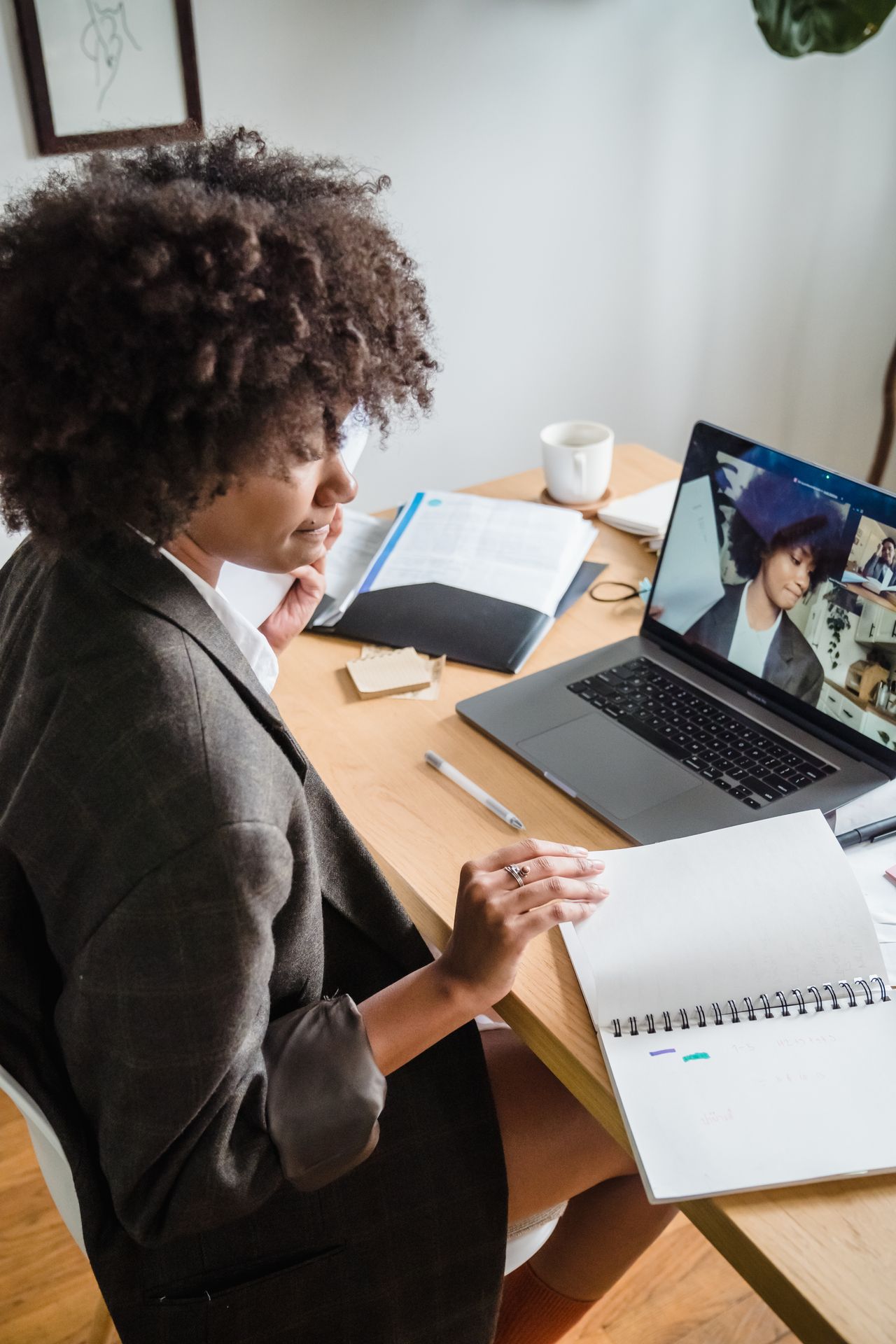 Businesswoman taking notes during a video conference, the kind of session GetResponse webinars host