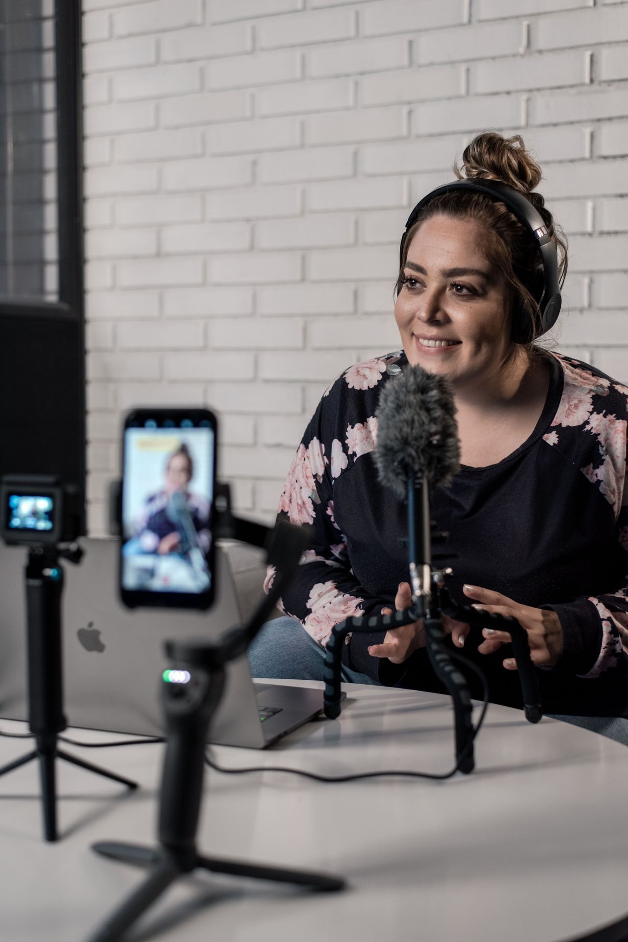 Woman recording a video podcast with a microphone, content that can be sold as a Payhip membership