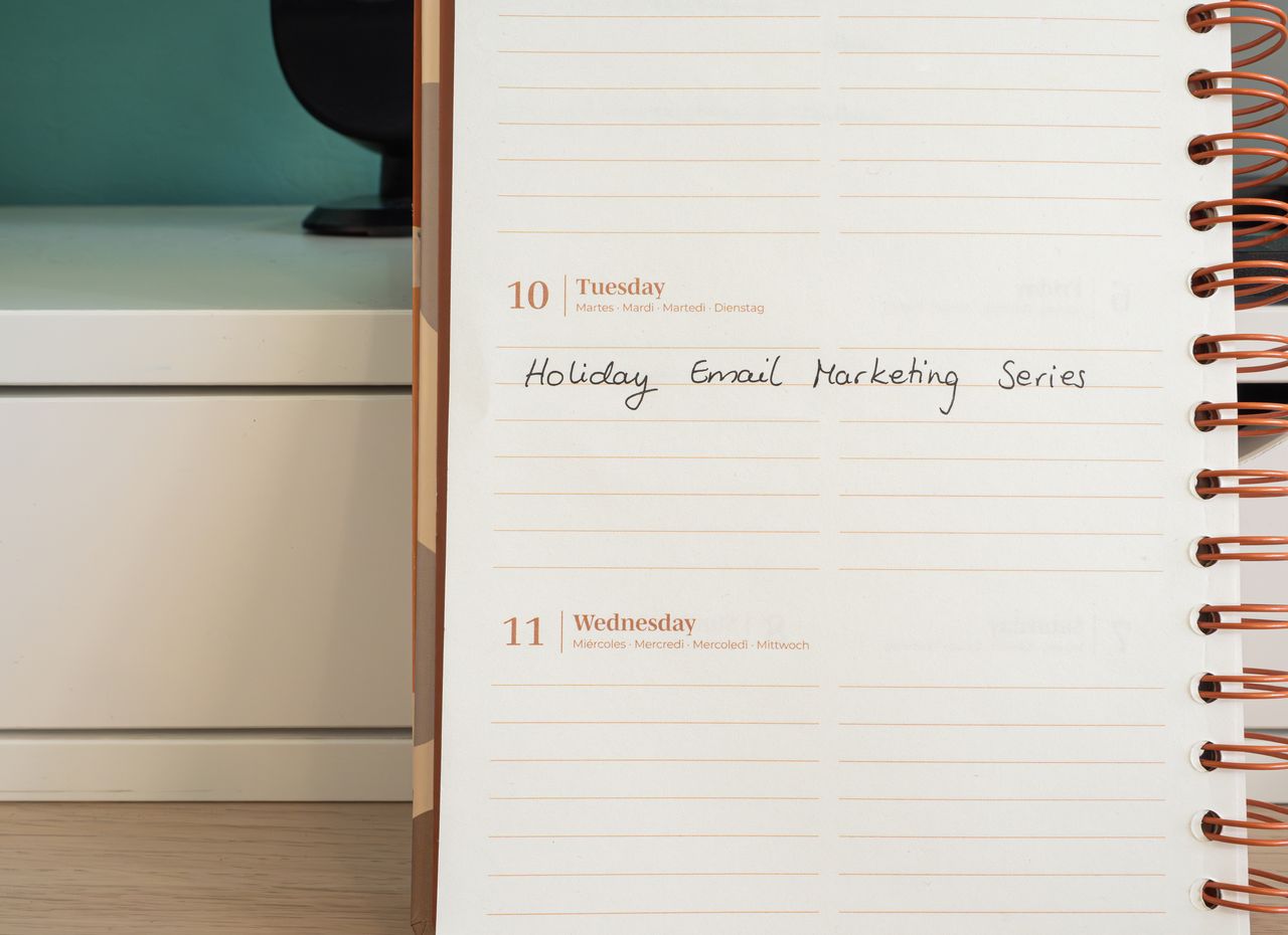 Planner with a handwritten email marketing series note, planning campaigns to send with AWeber
