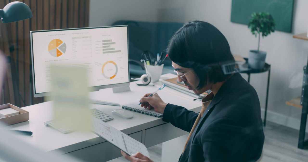 Business person reviewing analytics charts at a desk, like the reports in Benchmark Email