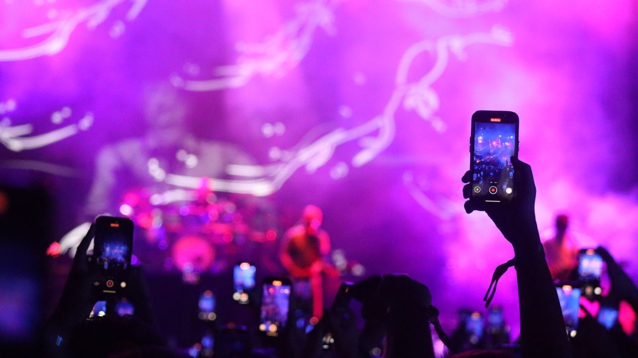 Concert crowd filming on smartphones, showing the fan reach behind the most-followed Instagram accounts