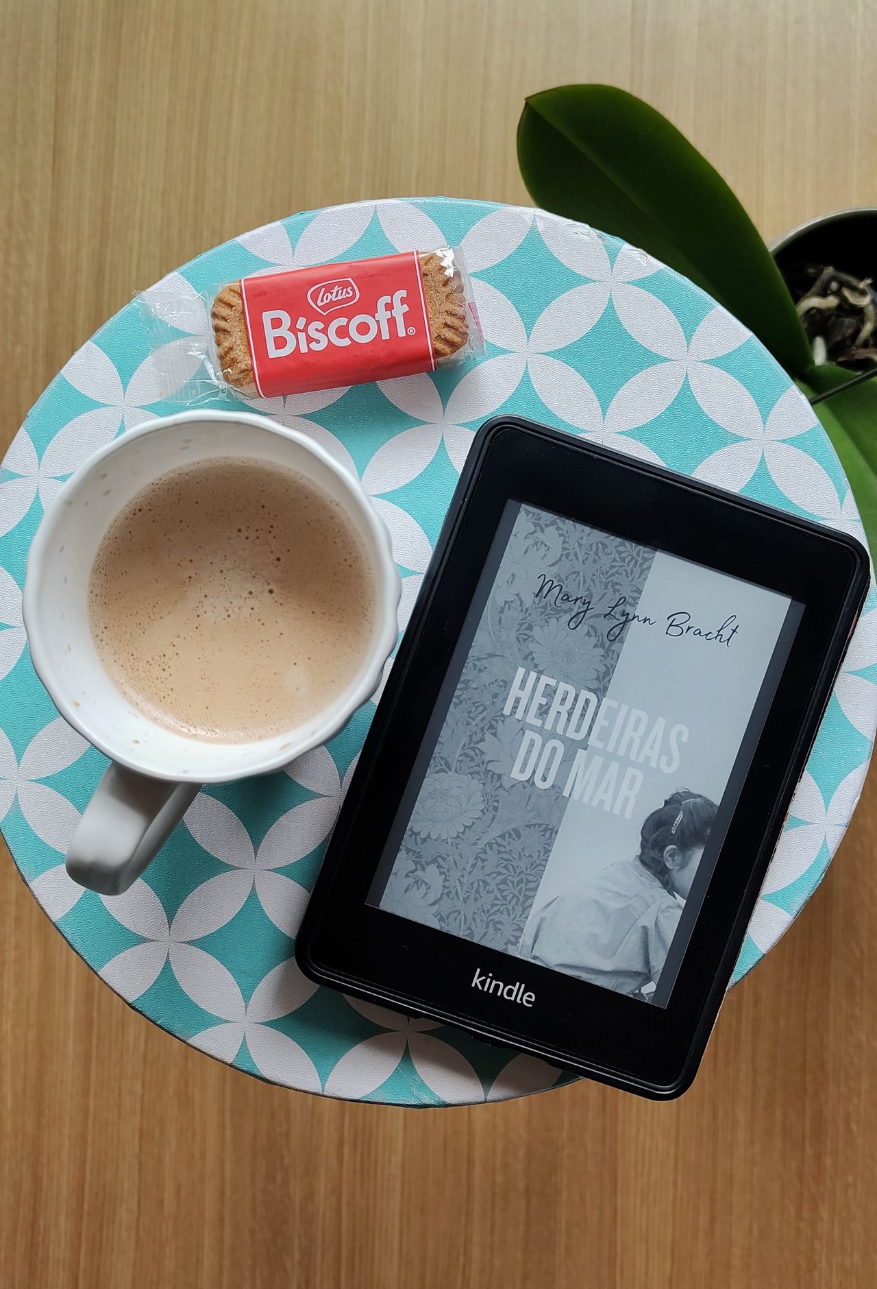 E-reader next to coffee and a biscuit; self-published eBooks are one way to earn passive income