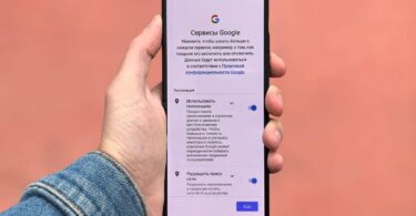 Hand holding an Android phone on the settings screen before deciding on an Instagram downloader APK