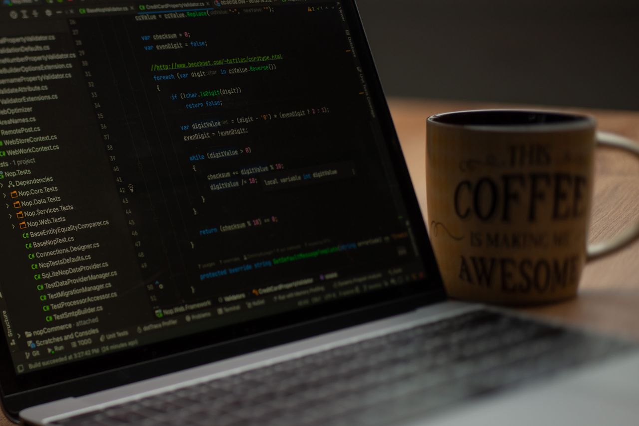 Laptop showing code next to a coffee mug, a typical setup for reading API data in a JSON viewer for Chrome
