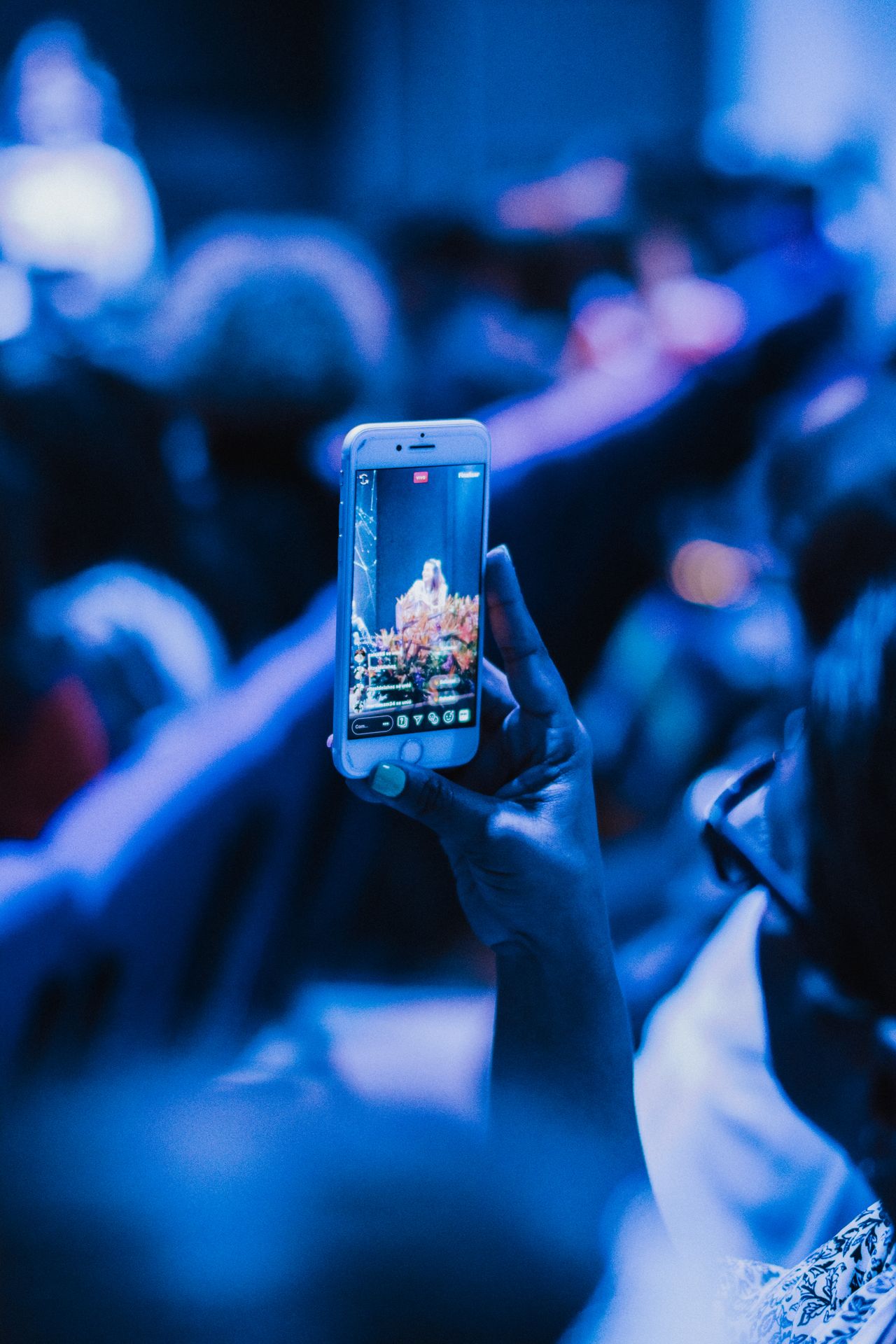 Person filming a live performance on a smartphone, a clip to save safely without a third-party video downloader