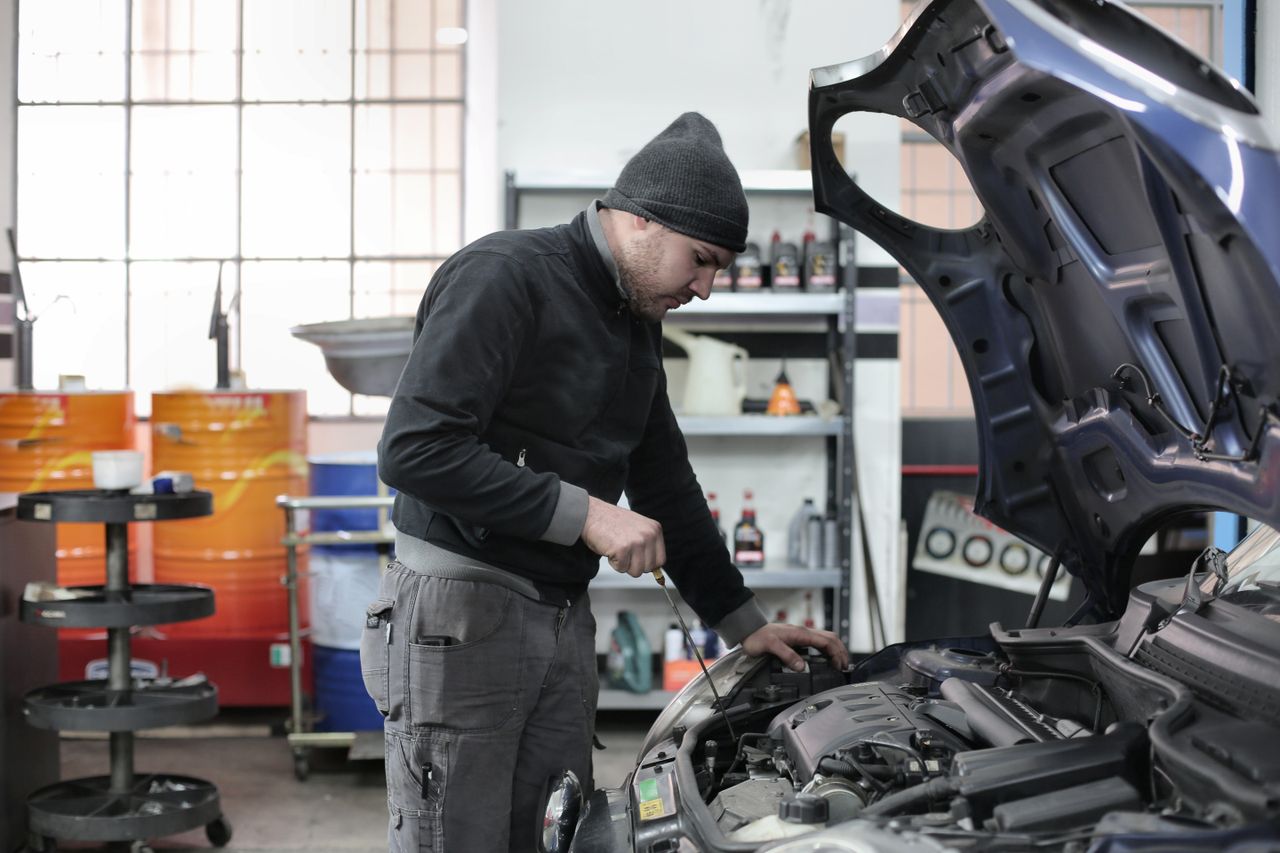 Mechanic inspecting a car engine in a garage, the auto parts buyers X-Cart Automotive is built to serve
