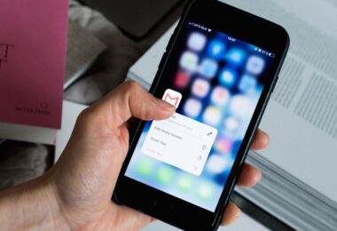 Hand holding a smartphone with an email app open, representing AWeber free email marketing