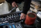 Mechanic choosing metal sockets in a workshop, for an X-Cart review of its auto parts ecommerce platform