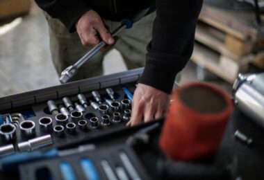 Mechanic choosing metal sockets in a workshop, for an X-Cart review of its auto parts ecommerce platform