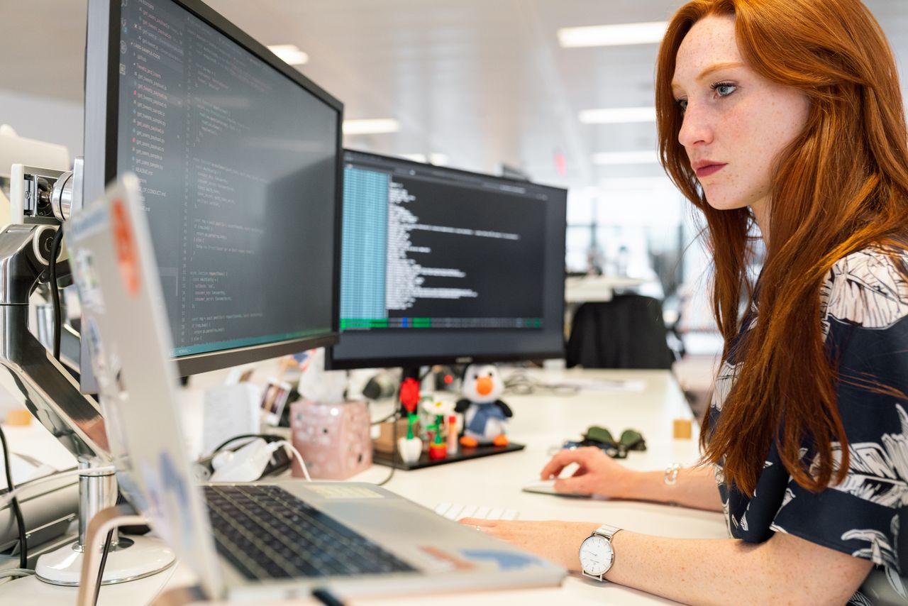 Woman writing code on a computer, testing JavaScript in an online JavaScript editor
