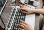 Woman using a laptop at her table, learning how to make extra money from home legitimately