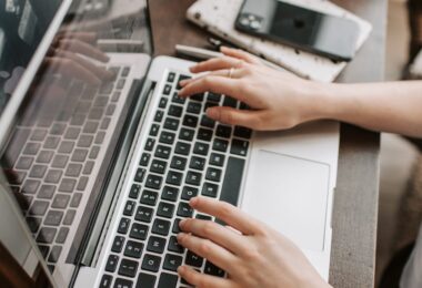Woman using a laptop at her table, learning how to make extra money from home legitimately
