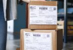 Stack of cardboard boxes with shipping labels ready to go out by standard shipping