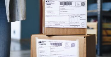 Stack of cardboard boxes with shipping labels ready to go out by standard shipping