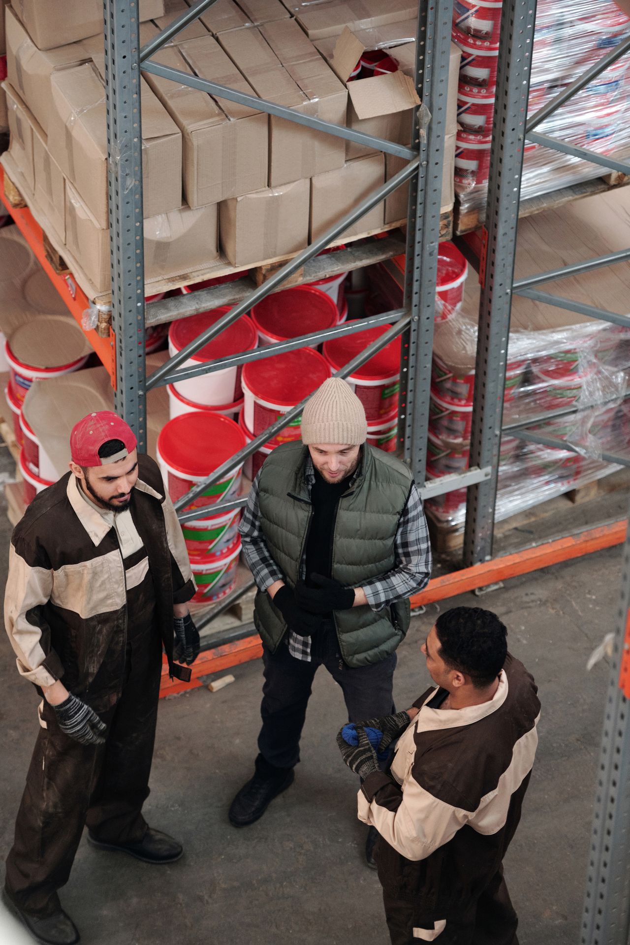 Warehouse team discussing order logistics among shelves, like the multi-center fulfilment UltraCart supports