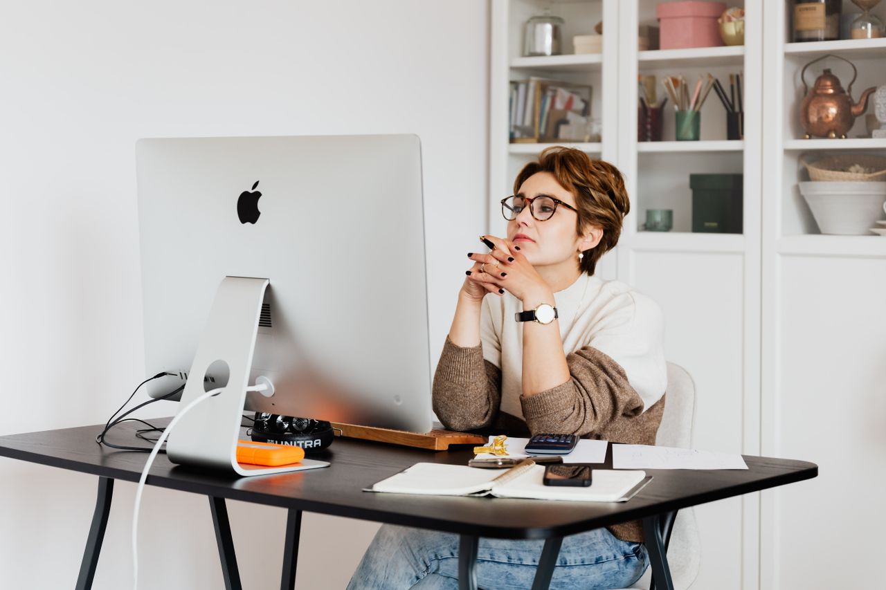 Woman reading details on a computer screen to check if a money making site is trusted