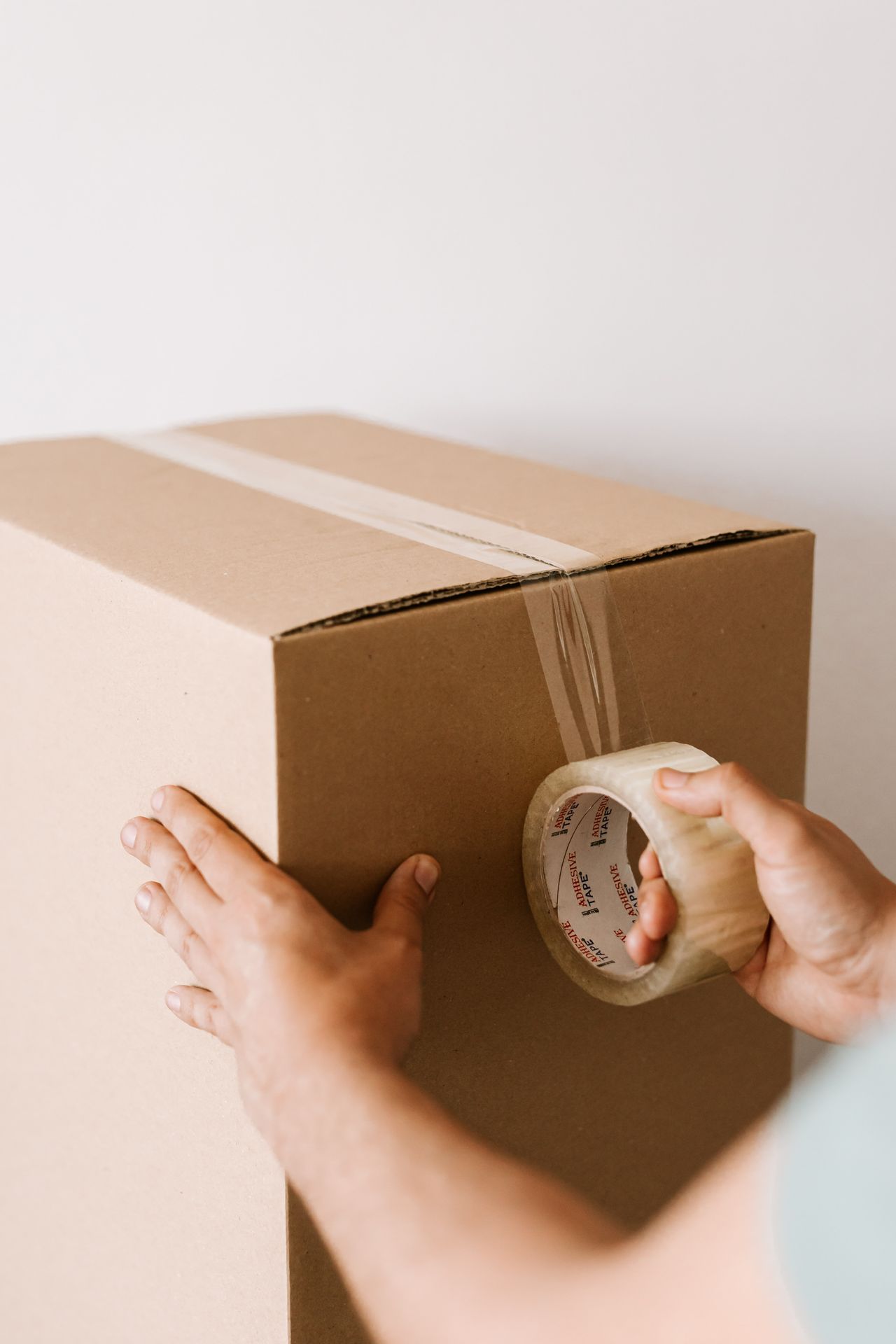 Seller sealing a shipping box with tape; Poshmark payment starts after the item ships and is delivered