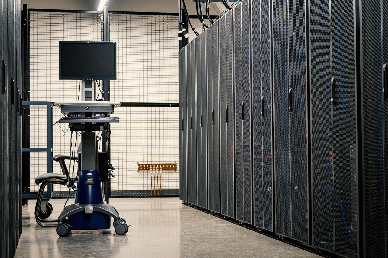 Black server hardware in a data center room, where shared web hosting plans run