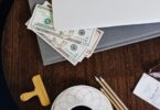 Paper money under a laptop, representing payouts from the best money making sites