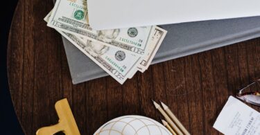 Paper money under a laptop, representing payouts from the best money making sites