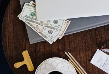 Paper money under a laptop, representing payouts from the best money making sites
