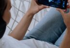 Person watching a video on a smartphone, showing how to make money watching ads on reward apps