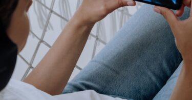 Person watching a video on a smartphone, showing how to make money watching ads on reward apps