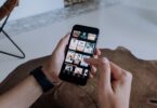 Person browsing videos on a smartphone while deciding whether an Instagram video downloader online is safe