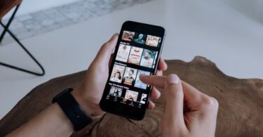 Person browsing videos on a smartphone while deciding whether an Instagram video downloader online is safe