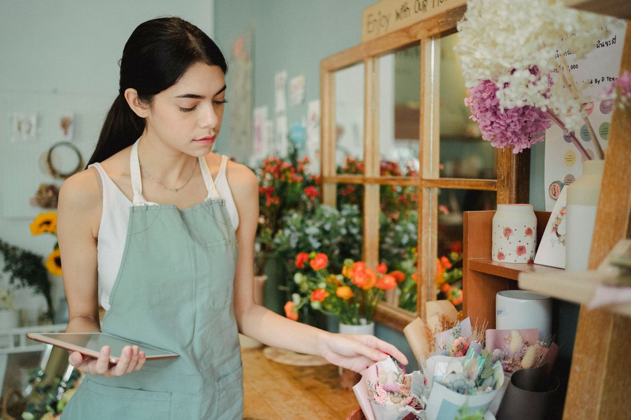 Florist checking an online order on a tablet, the kind of small shop that runs on Shopify