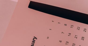 Paper calendars with weekly dates on a desk, planning around legit online jobs that pay weekly
