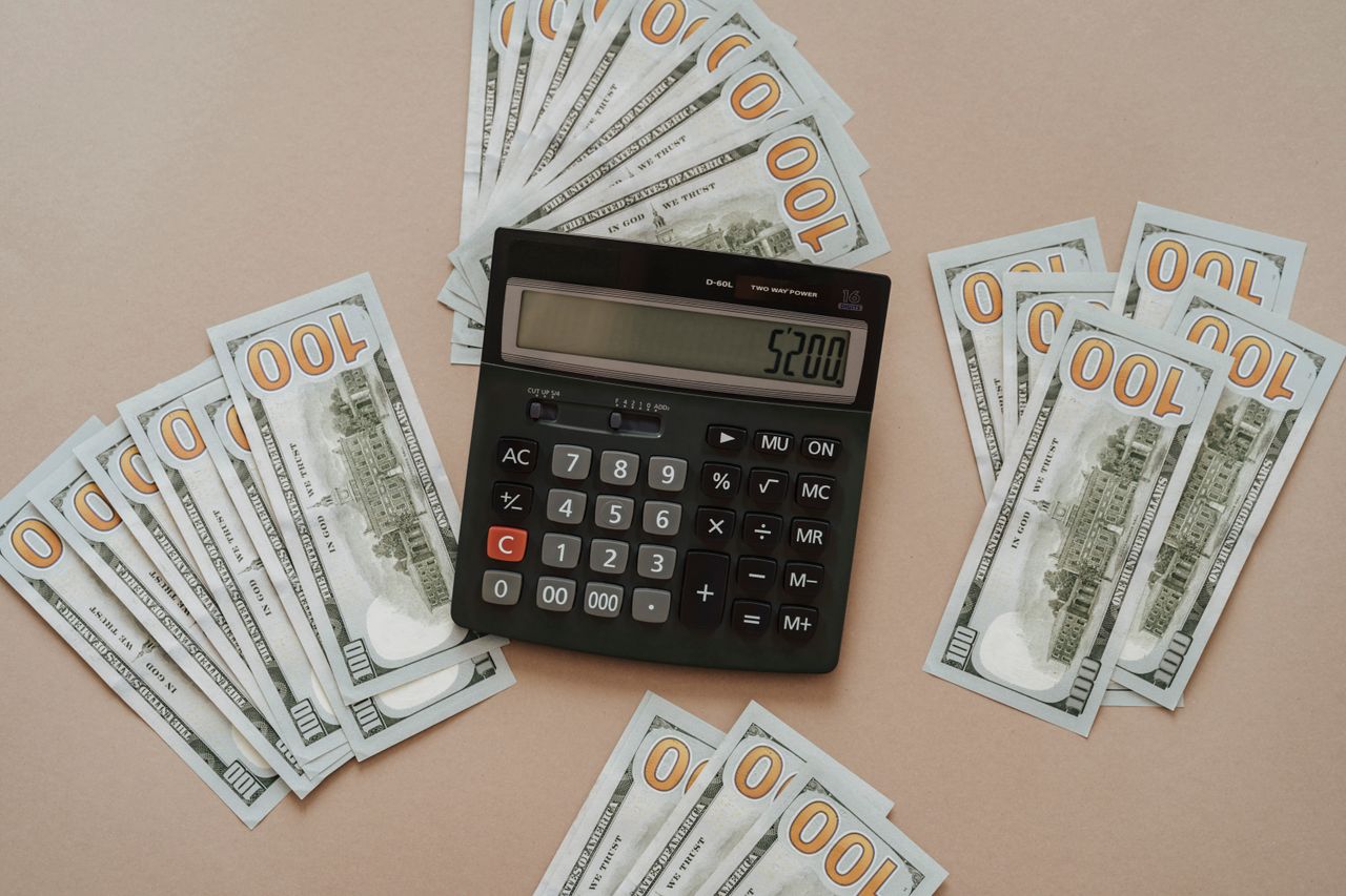 Calculator next to dollar bills for budgeting a small online business