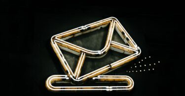Glowing neon envelope sign representing Sendloop email marketing and its alternatives in 2026
