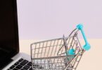 Miniature shopping cart on a laptop keyboard, illustrating the UltraCart hosted shopping cart review