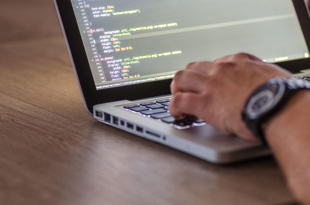 Person coding on a laptop while setting up a site on a new hosting service for website projects