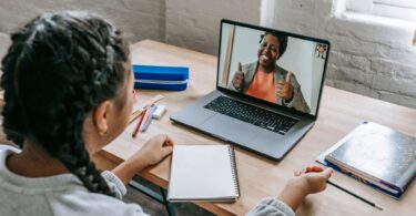 Student on a video call with a teacher on her laptop, one of many online jobs from home for students