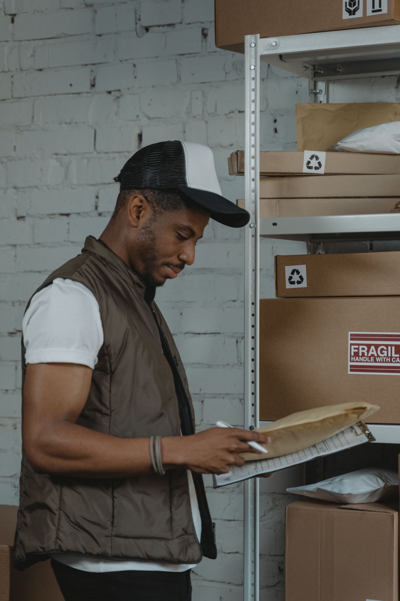 Warehouse employee organizing packages on shelves before they leave by economical standard shipping