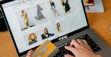 Woman paying by credit card in an online store on her laptop, for a 3DCart (now Shift4Shop) review
