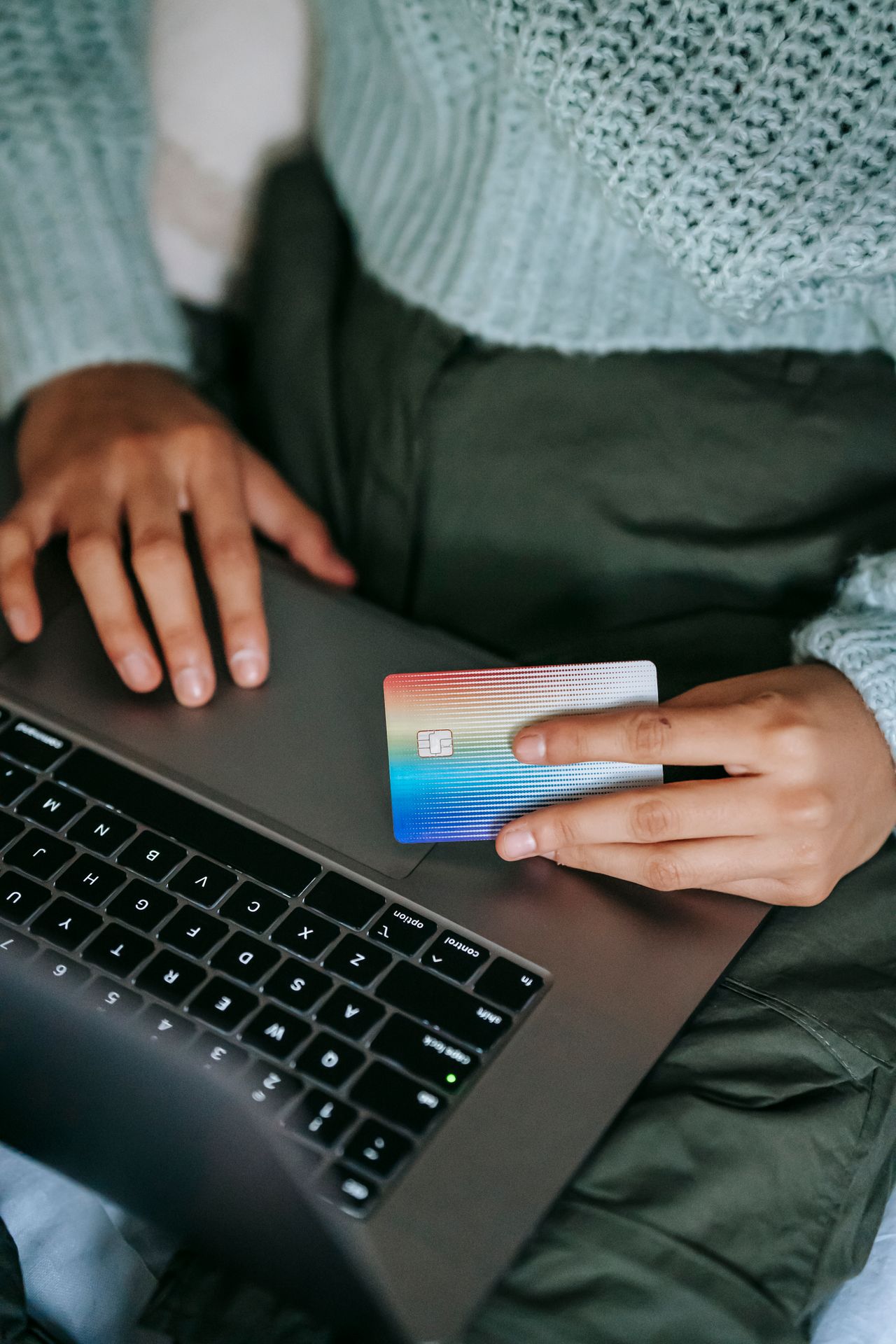 Buyer holding a bank card at a laptop checkout, the moment you buy web hosting and pick add-ons