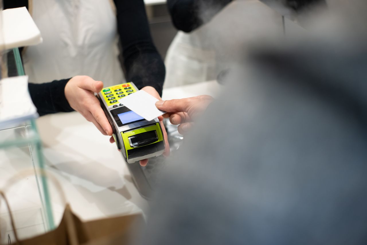 Customer paying by card at a payment terminal, the card processing behind the free Shift4Shop (3DCart) plan