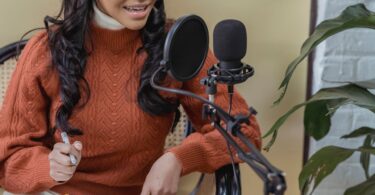 Creator recording a podcast with a microphone and laptop, the audience ConvertKit (now Kit) is built for