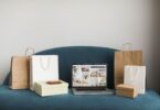 Laptop surrounded by shopping bags and boxes, representing an online store built with Ecwid