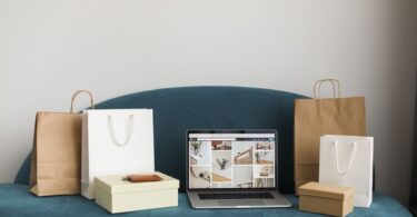 Laptop surrounded by shopping bags and boxes, representing an online store built with Ecwid