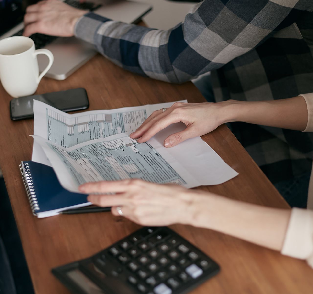 Person holding tax forms, a reminder that pay from online work at home is taxable