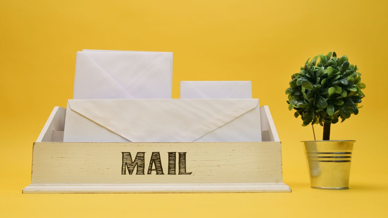 White envelopes in a wooden mail organizer, illustrating Benchmark Email pricing and sending limits