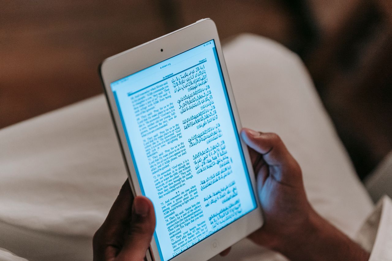 Person reading a purchased ebook on a tablet after SendOwl digital delivery