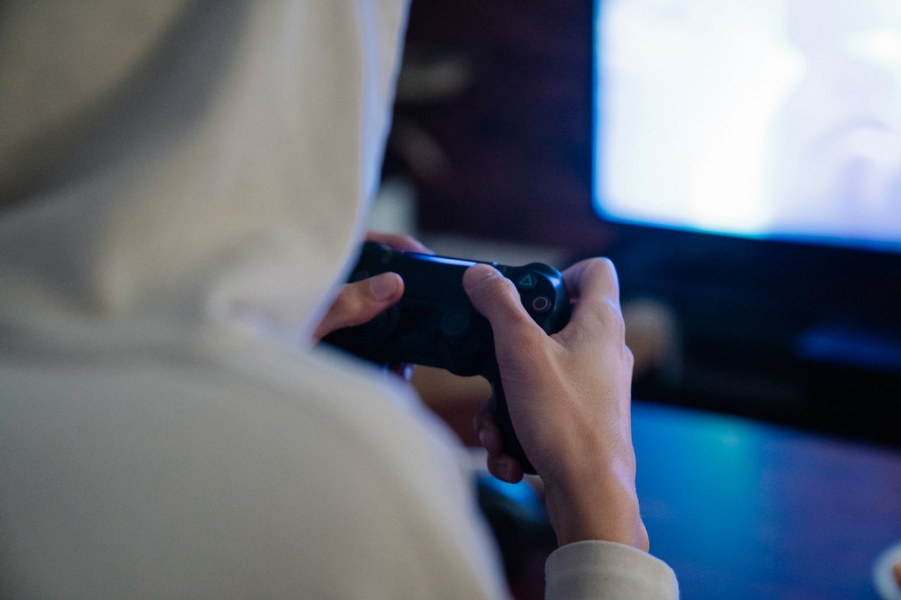 Gamer holding a controller in front of a monitor, grinding the best way to make money in GTA 5 Online