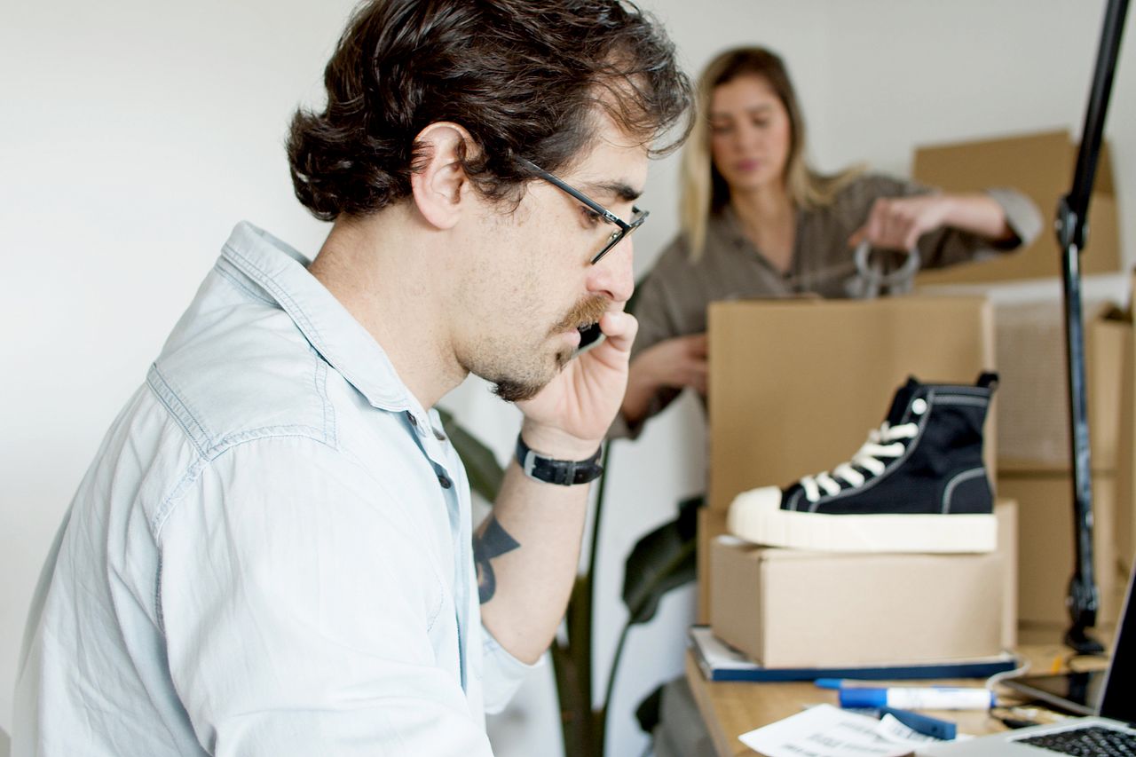 Small team taking a phone order and packing parcels, the daily work an ecommerce platform has to support